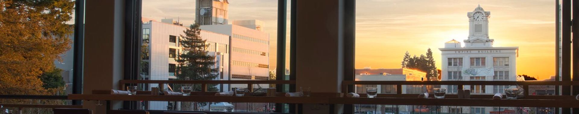 Window view overlooking plaza with sunset and historic Sonoma County courthouse.