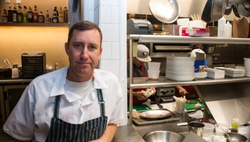 Chef Mike Mullens standing outside kitchen at Perch + Plow restaurant.