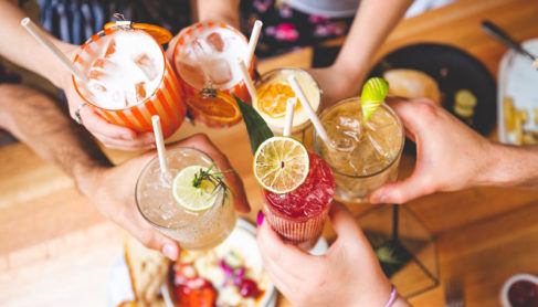 A group of friends say cheers with a collection of creative cocktails.