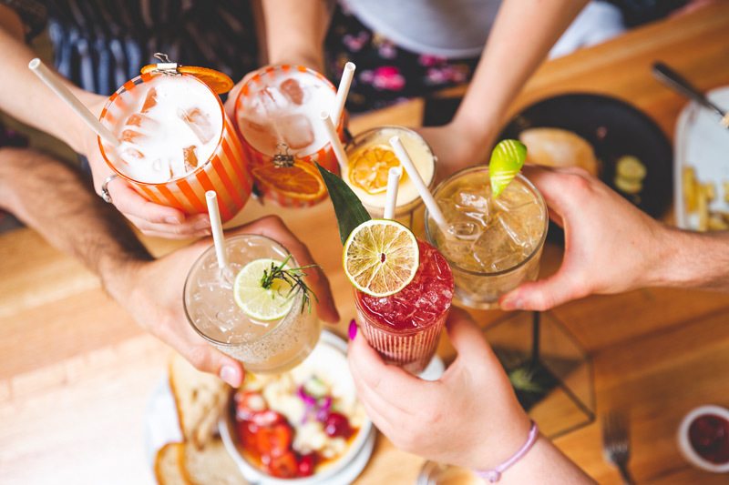 A group of friends say cheers with a collection of creative cocktails.